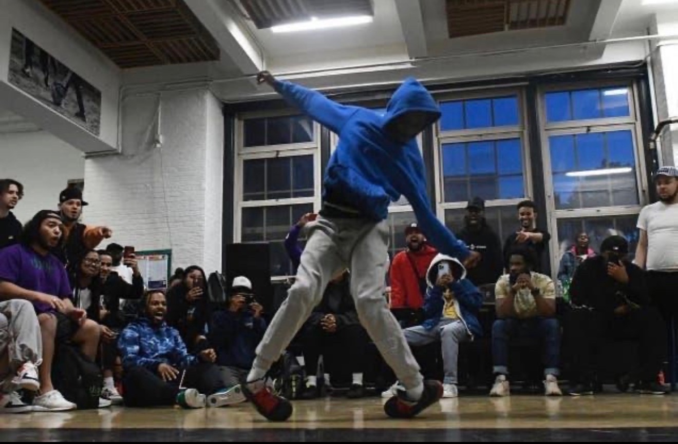 Kid Pat performing Lite Feet during a dance battle surrounded by spectators