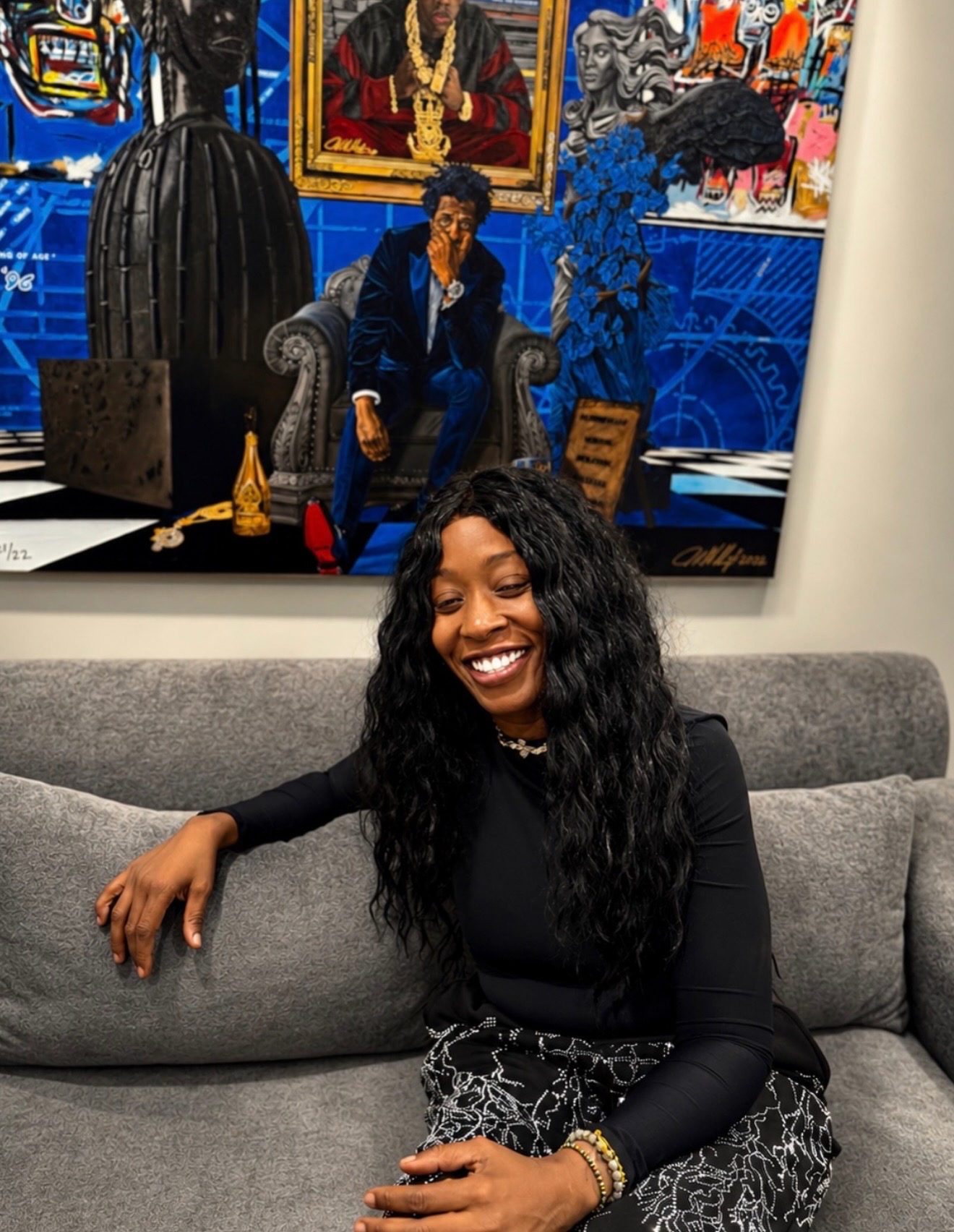 Misty Blanco seated beneath an original artwork