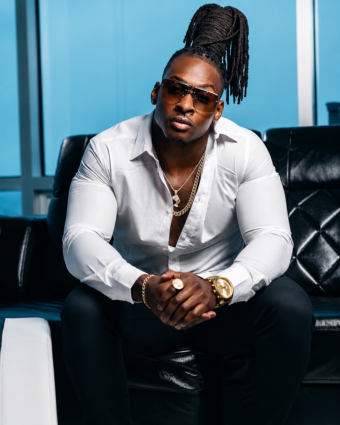 Money Train North Carolina recording artist and entrepreneur seated in a white shirt