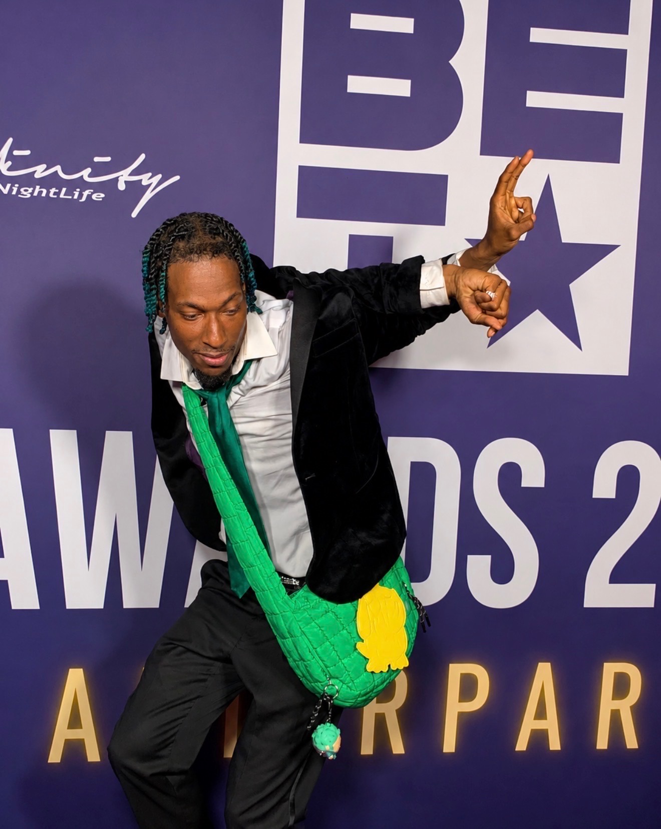 Guest posing at the BET Awards afterparty purple backdrop during entertainment media coverage