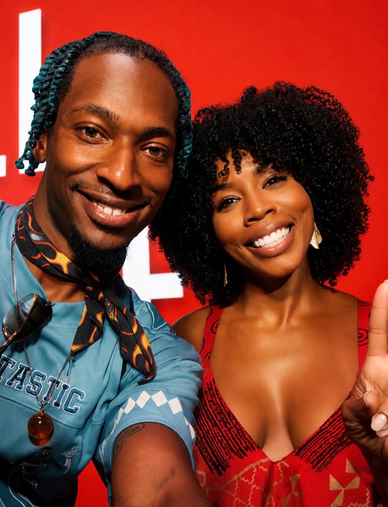 Two guests smiling in a BET Awards 2026 red backdrop selfie during entertainment event coverage