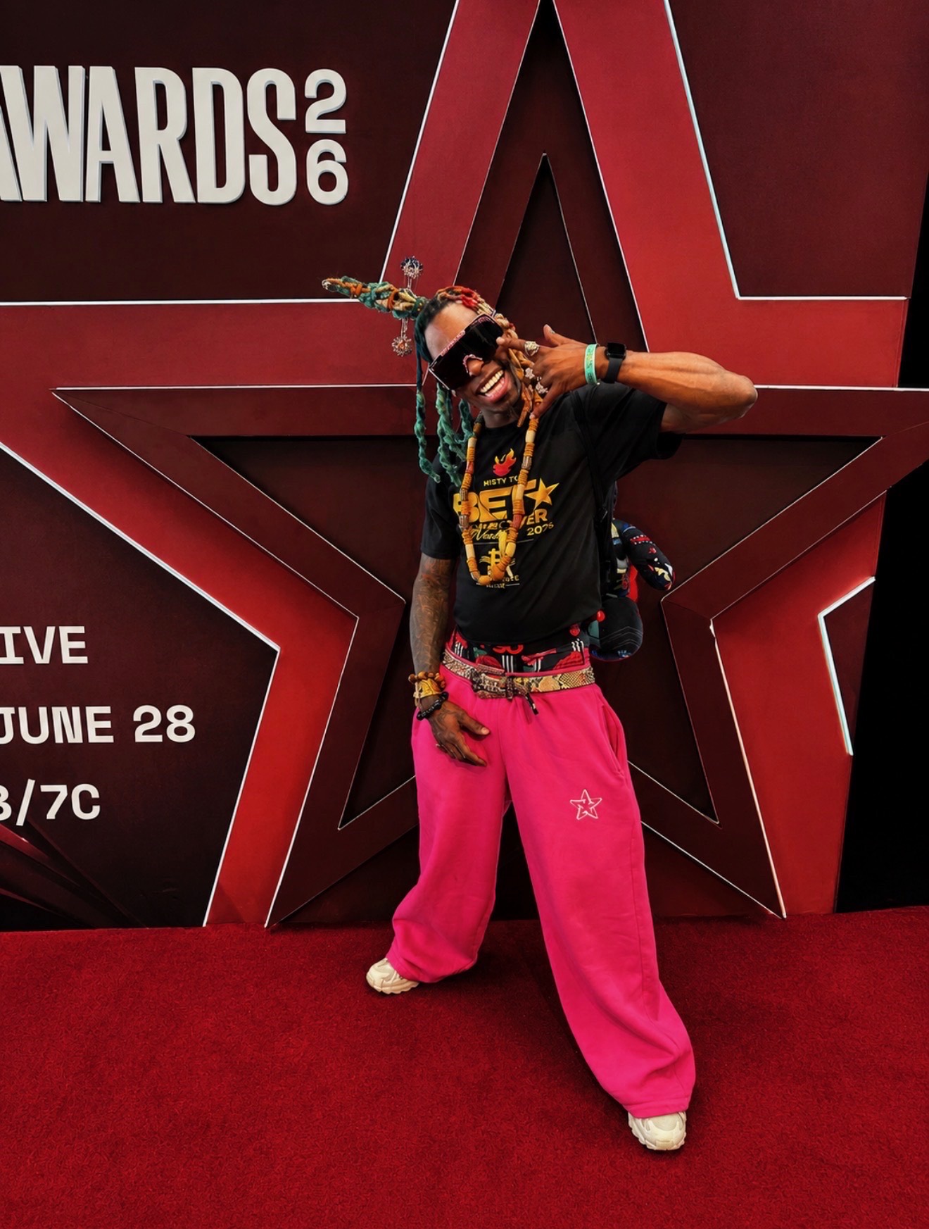 Guest posing on the BET Awards 2026 red carpet in pink pants during entertainment media coverage