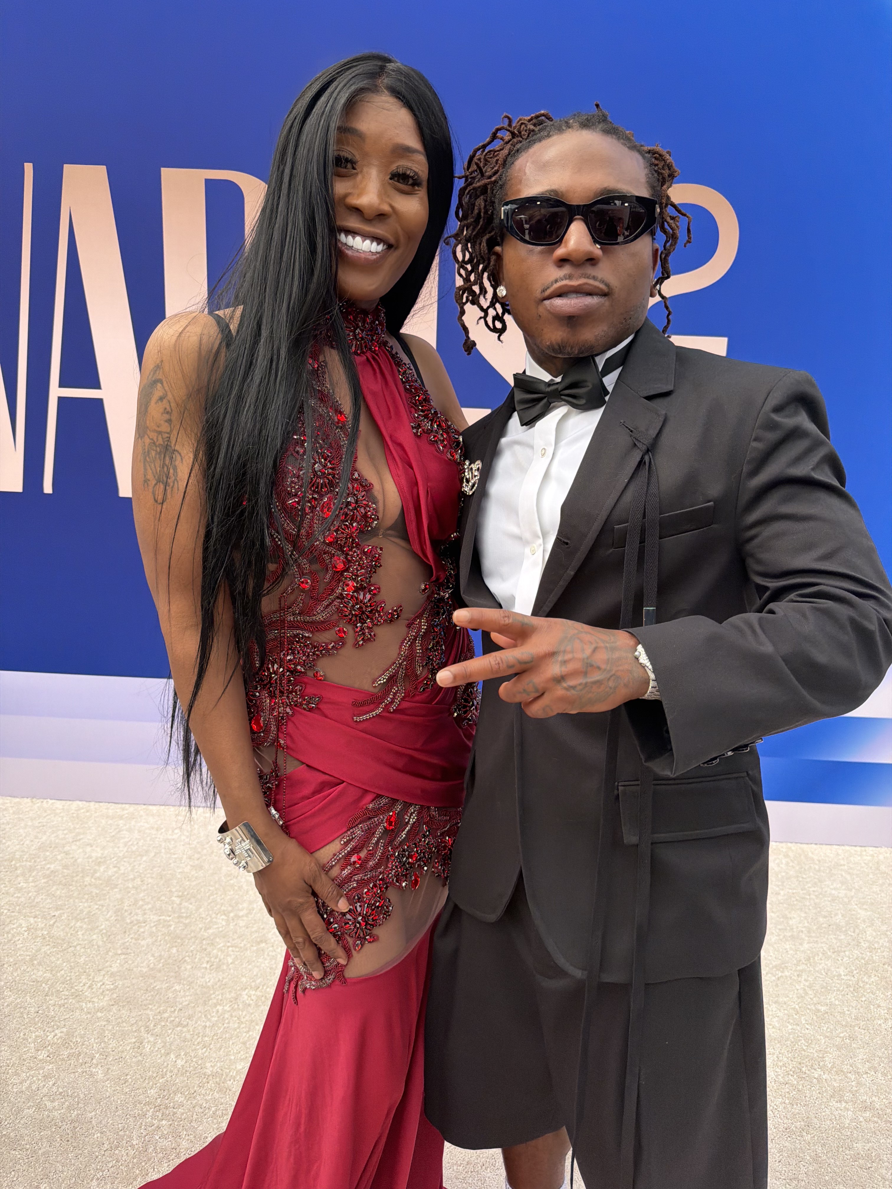 Misty Blanco in a red dress with an entertainment guest during BET Awards 2026 celebrity interview coverage