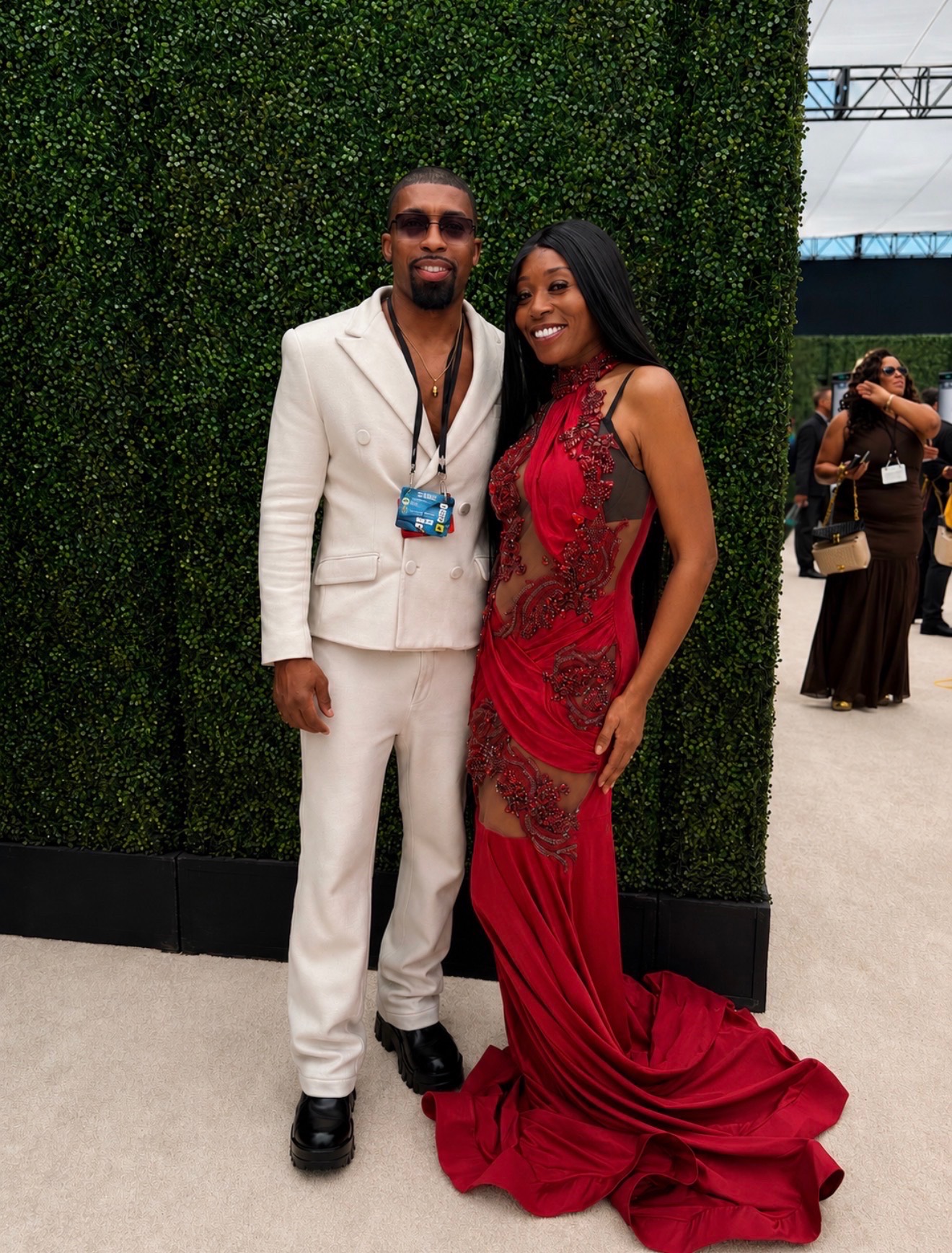 Misty Blanco posing with a guest in a white suit during BET Weekend 2026 red carpet media coverage